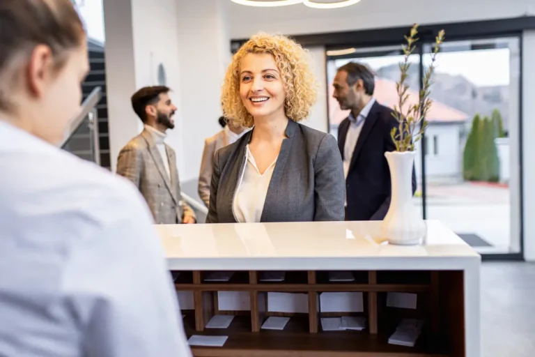 businesswoman talking to a receptionist at a well furnished entryway area